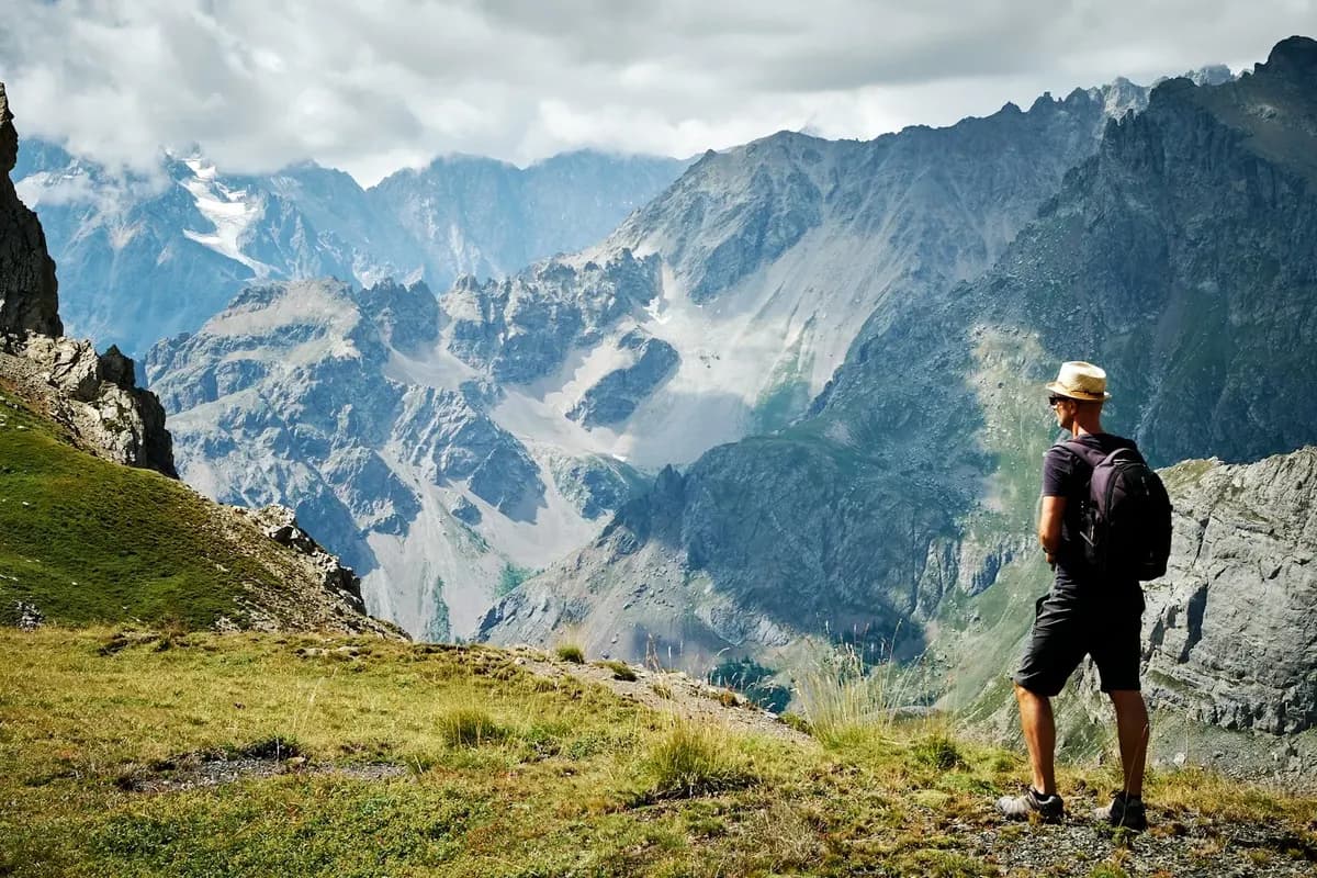 Wanderer mit Rucksack vor einer Bergkulisse